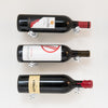 Wall wine bottle display with three bottles on round metal pins; black rack finish