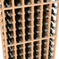 Wine bottle rack interior view, 6 columns, light wood dividers holding dark bottles