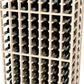 Close-up of white wine bottle rack lattice holding bottles in double-deep rows