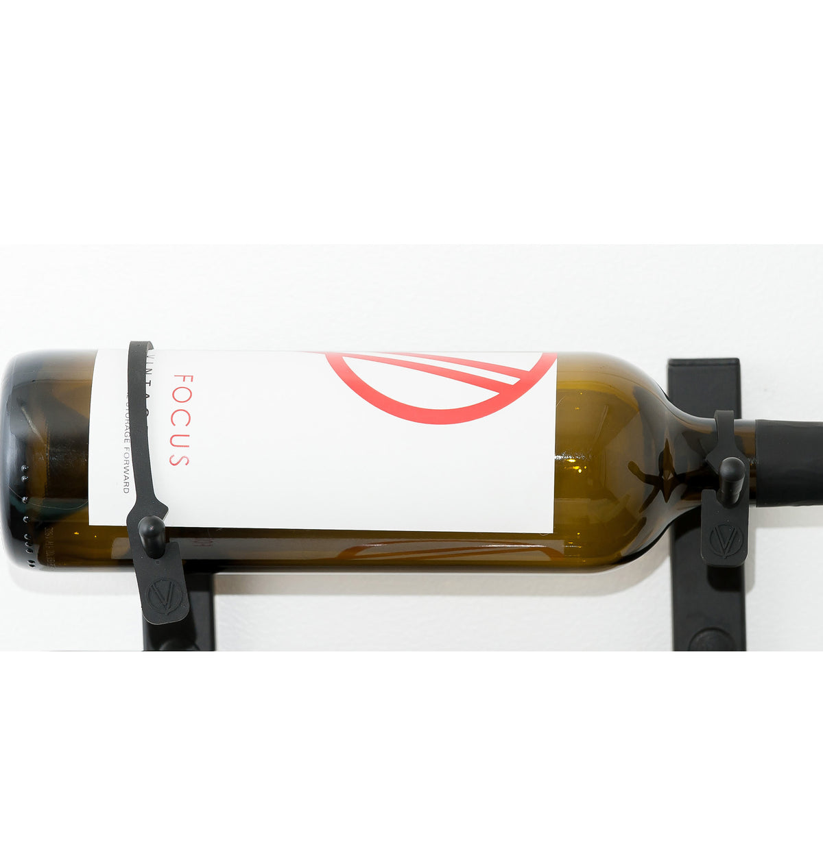 Wall-mounted bottle retention strap, black clips securing a bottle on a bar