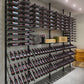 Wine storage wall with multiple two-bottle racks and row of bottles in holders