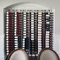 Wall standoff bracket, not clearly visible; wall of wine bottles fills the frame
