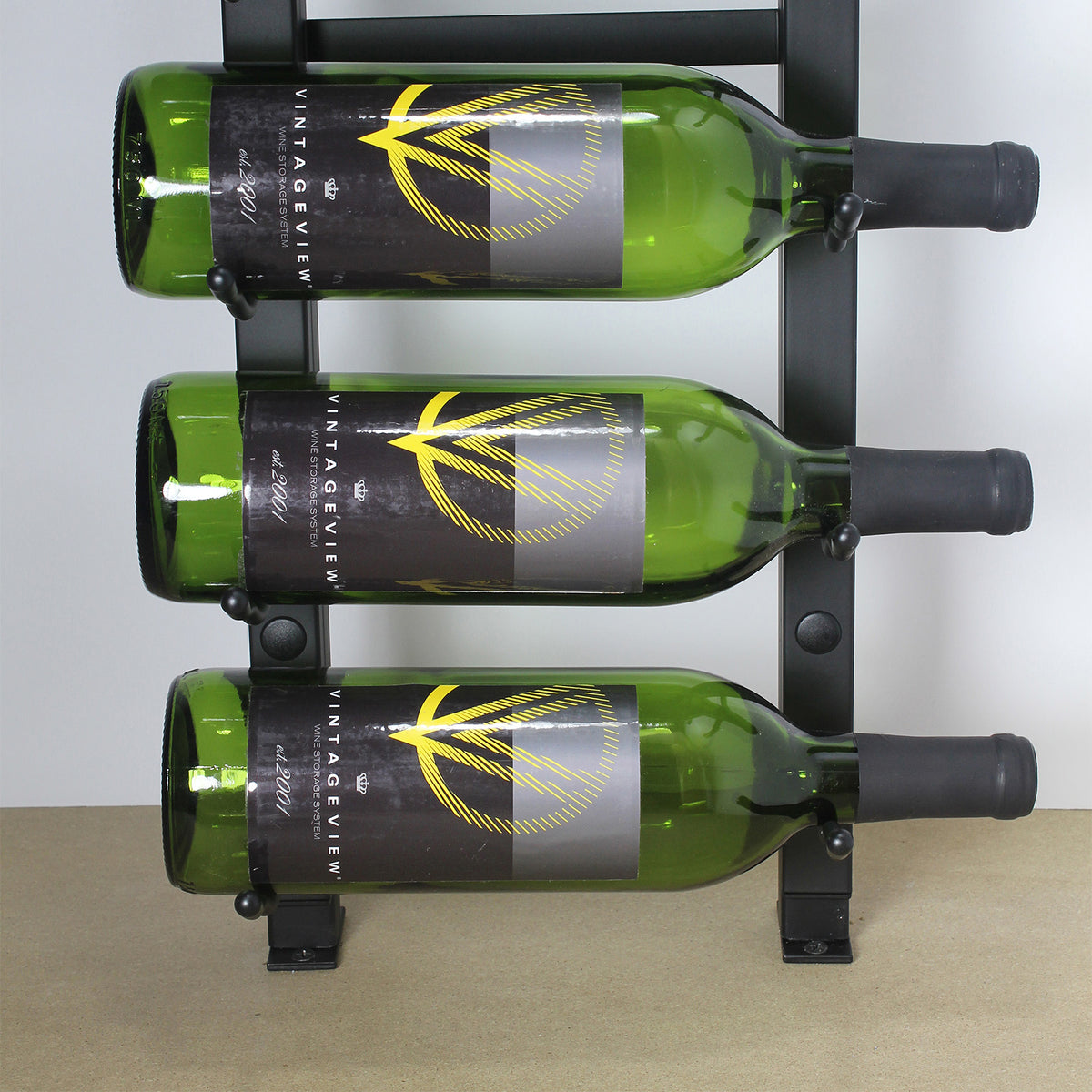 Wall wine bottle display with green bottles in a black metal frame and hidden base mounts
