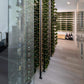 Wine storage wall with bottle display frames, rows of wine bottles, and vertical metal supports