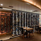 Double-sided wall wine rack with multiple rows of filled wine bottles behind panels
