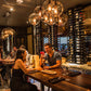 Double-sided wall wine rack with filled wine bottle slots, wall-mounted