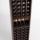 Dark wood wine bottle rack interior with rows of bottles and stemmed glass shelf