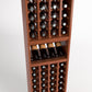 Wood wine bottle rack with four columns, bottle caps visible, and middle display shelf