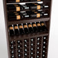 Close-up of wood wine rack with horizontal bottle rails, display shelf, and cellar bottle storage cubbies