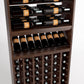 Brown wood wine rack close-up with top bottle rails, middle bottle shelf, and bottom bottle cubbies