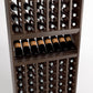 Wood wine bottle rack close-up showing angled bottle slots and front row shelf