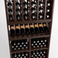 Dark wood wine rack close-up with bottle slots, front curved bottle shelf, and cubby storage.
