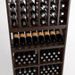Close-up wine rack: bottle slots, wine bottles, and metal-topped bottle openings