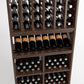 Wood wine rack section with upright bottle rows and cubbies holding bottles horizontally