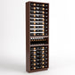 Tall wood wine bottle display rack with 6 columns, holding bottles and a mid tray