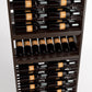 Wood wine rack close-up with bottle storage slots and a front row resting on a shelf