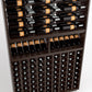 Dark wood wine rack close-up with top rails and multiple rows of bottles in cubbies