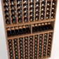 Wood wine bottle rack close-up showing grid slots, bottles, and two front shelves