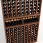 Wood wine bottle rack close-up with bottles in grid slots and front shelf rows
