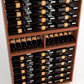 Multi-tier wine bottle display rack with dark bottles and orange label bands
