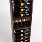 Dark wood wine bottle rack with horizontal slots holding bottles and glass compartments