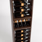 Angled view of wooden wine rack with bottle slots on rail supports and wine bottles