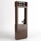 Cabinet-style wine tasting station with top wine rack, open center frame, bottle and glass