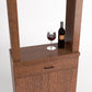 Espresso-brown cabinet tasting station with two doors, drawer, and top wine bottle & glass