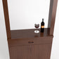 Medium brown wood cabinet tasting station with doors and drawer, wine bottle and glass
