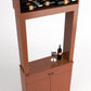 Close-up view of wood tasting cabinet with bottle rack above and wine glass set