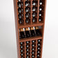 4-column wine cellar rack close-up with bottle cubbies, wine glass shelf, medium wood.