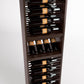 Dark wood wine bottle display rack with rows of bottles in horizontal rails