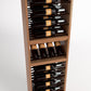 Light wood wine bottle display rack with rows of bottles in black horizontal rails