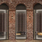 Low-profile wine bottle display with dark metal shelves and stacked bottle rows