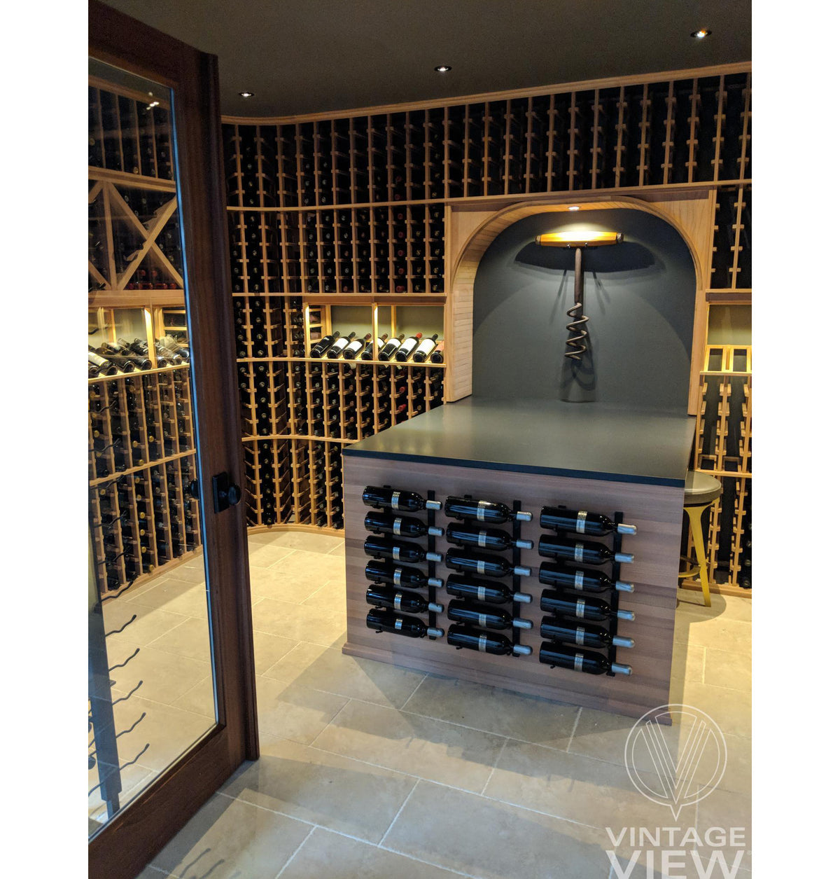 Wall-mounted wine bottle rack with dark frame and rows of bottles in a display bay