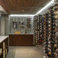 Wall-mounted wine bottle rack with metal pegs and rows of bottles on side panels