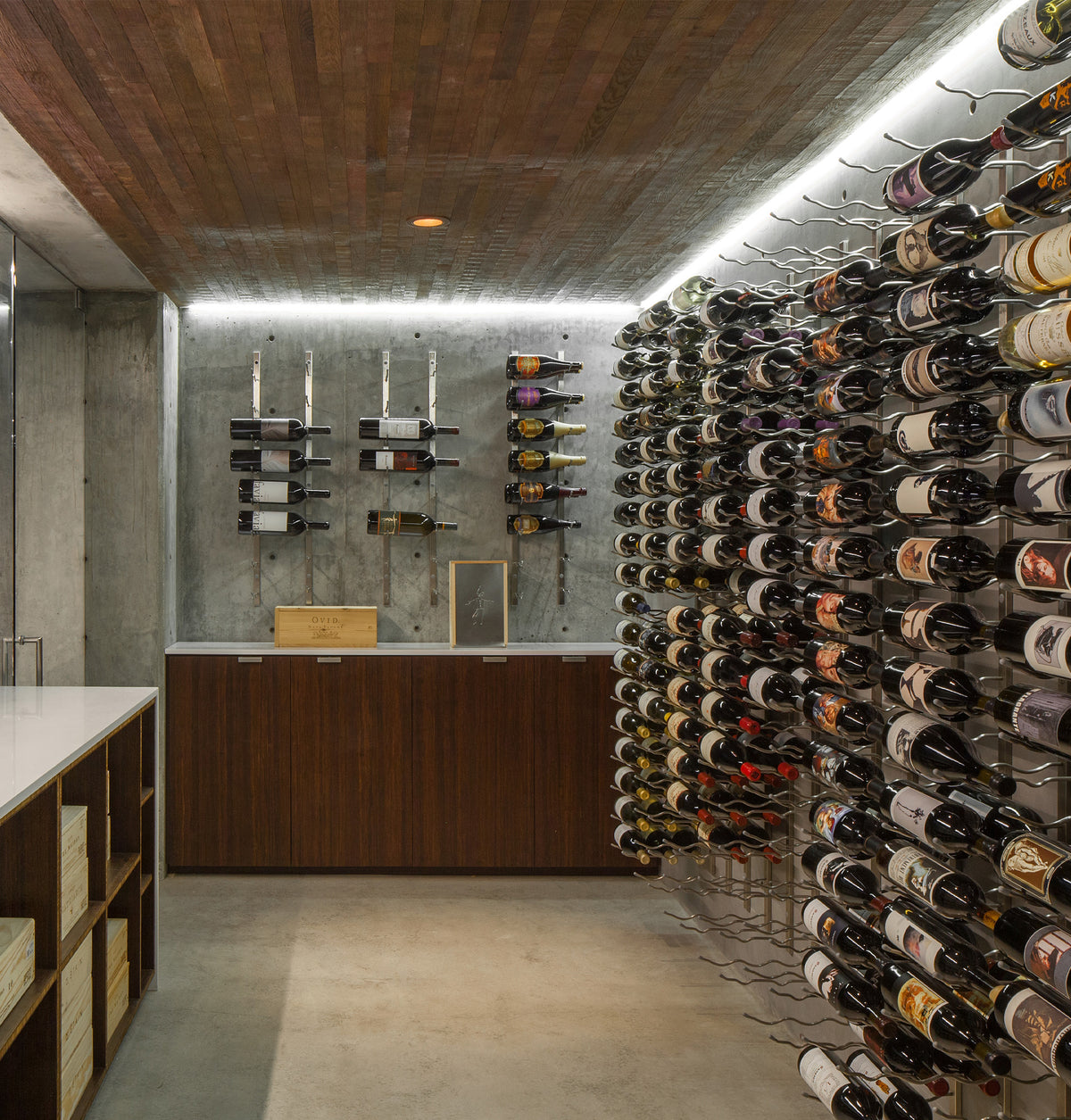 Wall-mounted wine bottle rack with metal pegs and rows of bottles on side panels