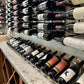 Wall row wine bottle rack with assorted labels and corks in black bottle necks