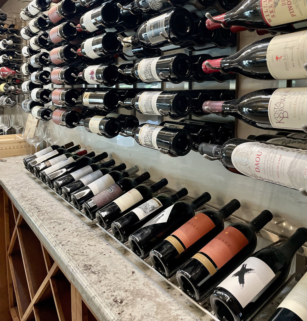 Wall row wine bottle rack with assorted labels and corks in black bottle necks