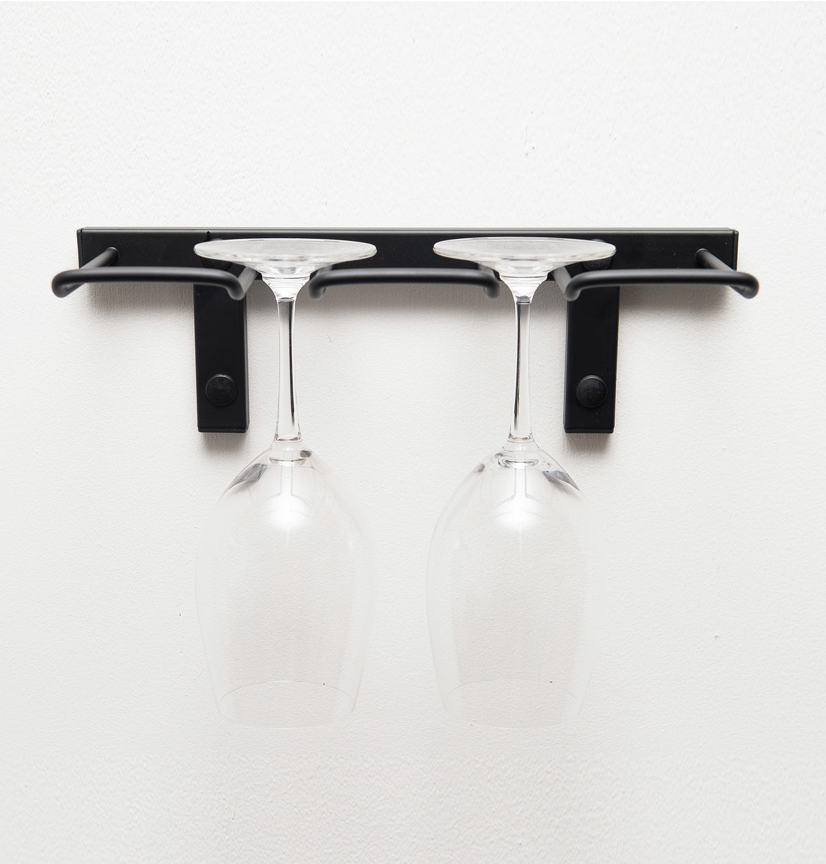 Black wall-mounted stemware rack with two glass cups hanging from hooks
