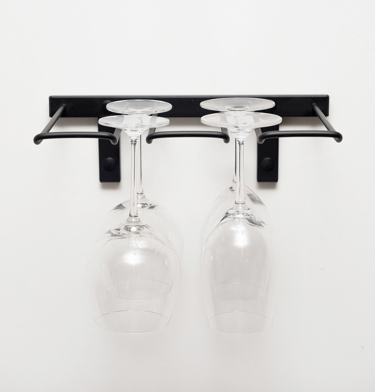 Black wall-mounted stemware rack with two hanging wine glasses