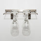 Silver-tone wall-mounted stemware rack holding two wine glasses