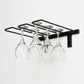 Black wall-mounted stemware rack holding six wine glasses