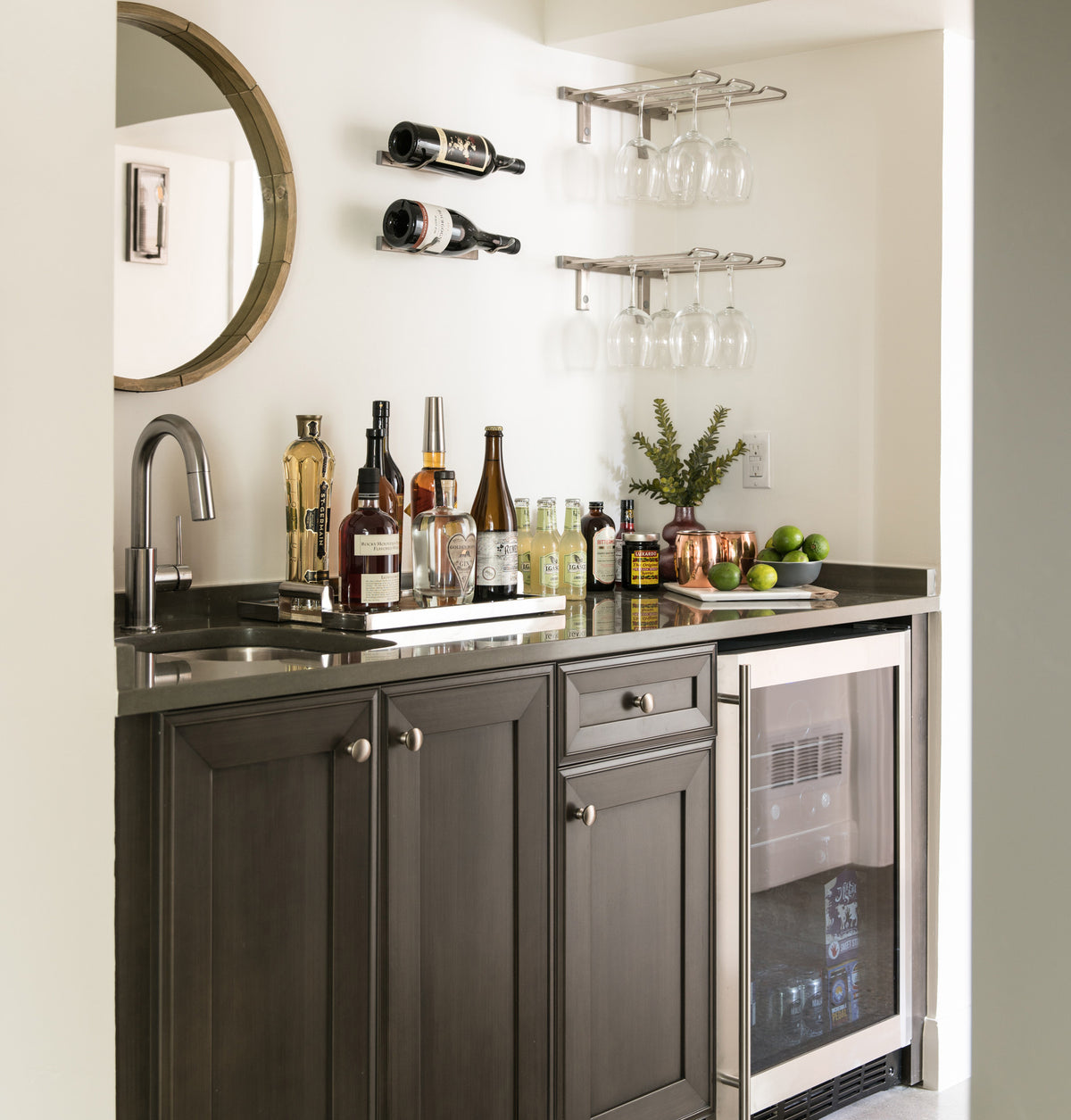 Wall-mounted stemware rack above a countertop with hanging wine glasses