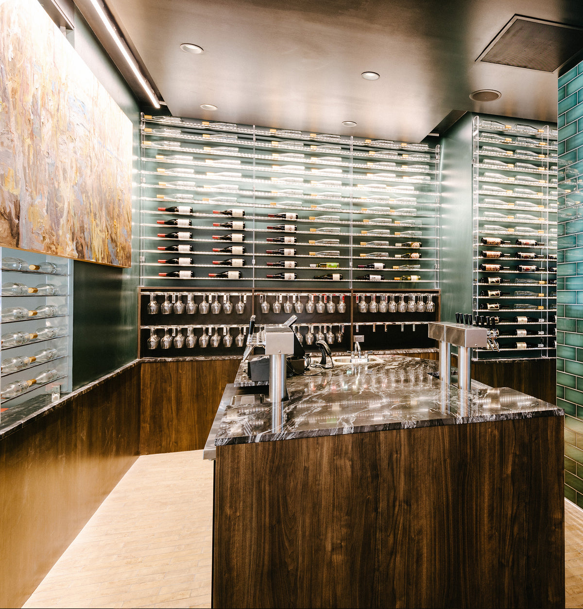 Wall-mounted stemware rack with hanging glassware near a bar counter