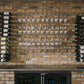 Wall-mounted bar rack with hanging wine glasses in rows