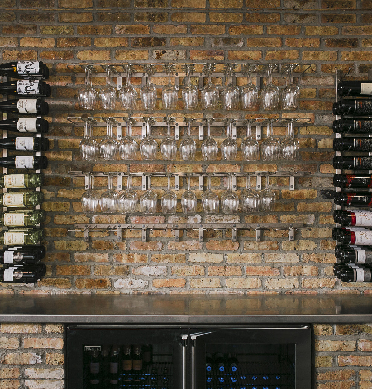 Wall-mounted bar rack with hanging wine glasses in rows