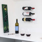 Wall-mounted wine bottle pins holding three bottles with metal fasteners
