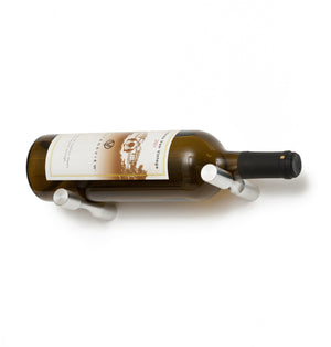 Wine bottle holder pins with gunmetal prongs on a golden glass wine bottle