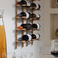 Wall-mounted wine bottle rack with bottles stored on golden bronze slots